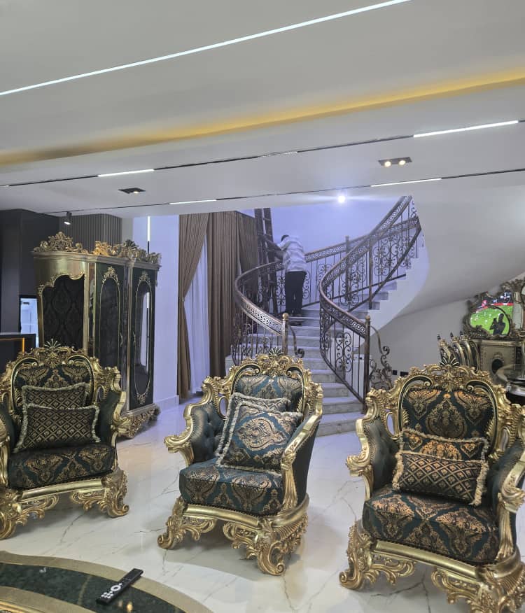 Luxury living room with ornate custom furniture and curved staircase