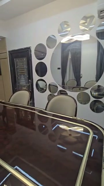 Luxury dining area with custom mirror feature wall